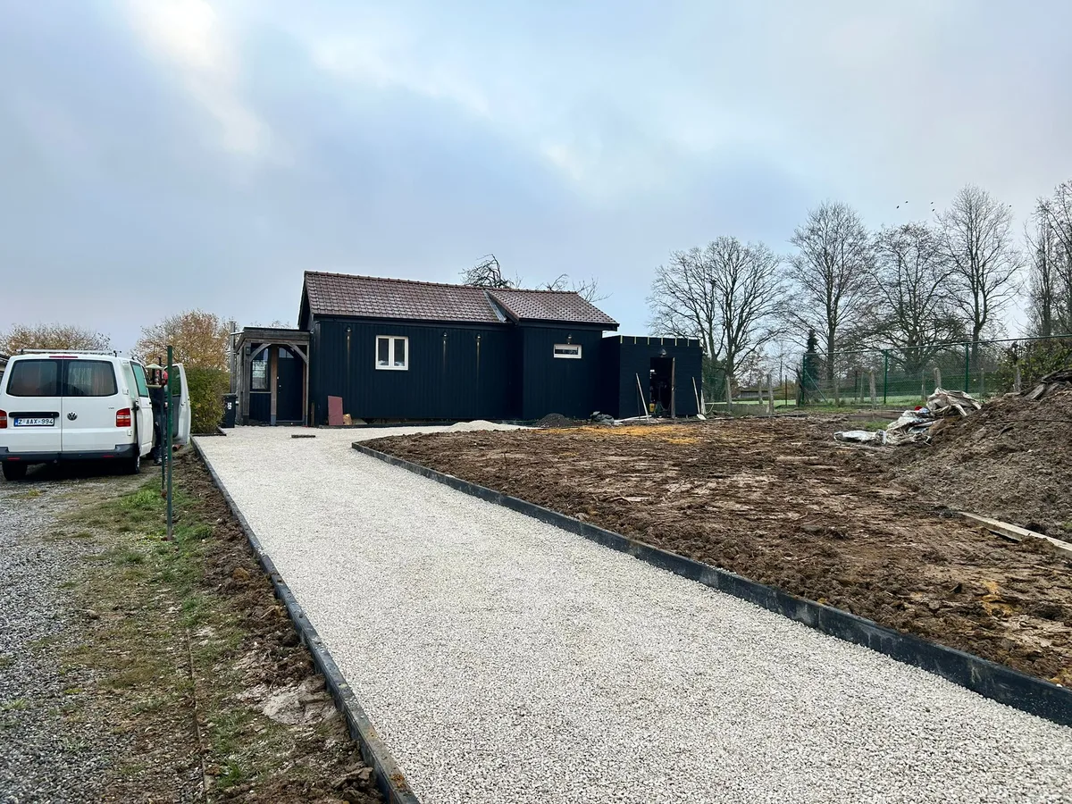 Allée en gravier stabilisé menant à un chalet en construction